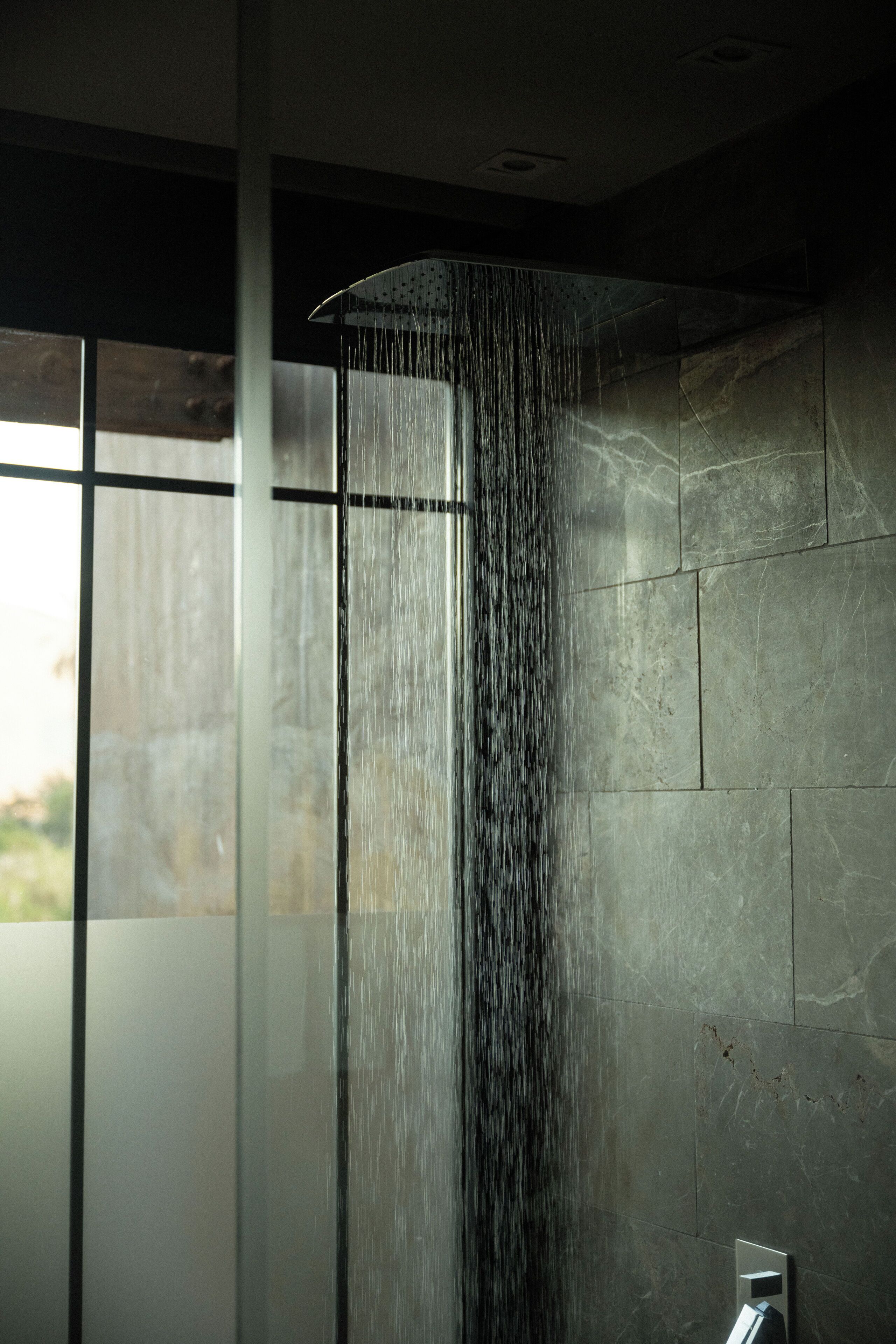 A modern shower with a curved design and a visible water stream.