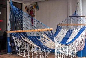 Relax in a hammock chair suspended by a wooden frame, perfect for unwinding in this serene space.