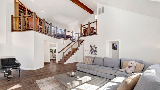 A spacious living room with a grand staircase, a piano, and a cozy sofa. - Splash Mountain #1904 (Big Bear Lake)