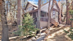A cabin with a stone chimney, wooden deck, and a stone pathway leading to the entrance. - Splash Mountain #1904 (Big Bear Lake)
