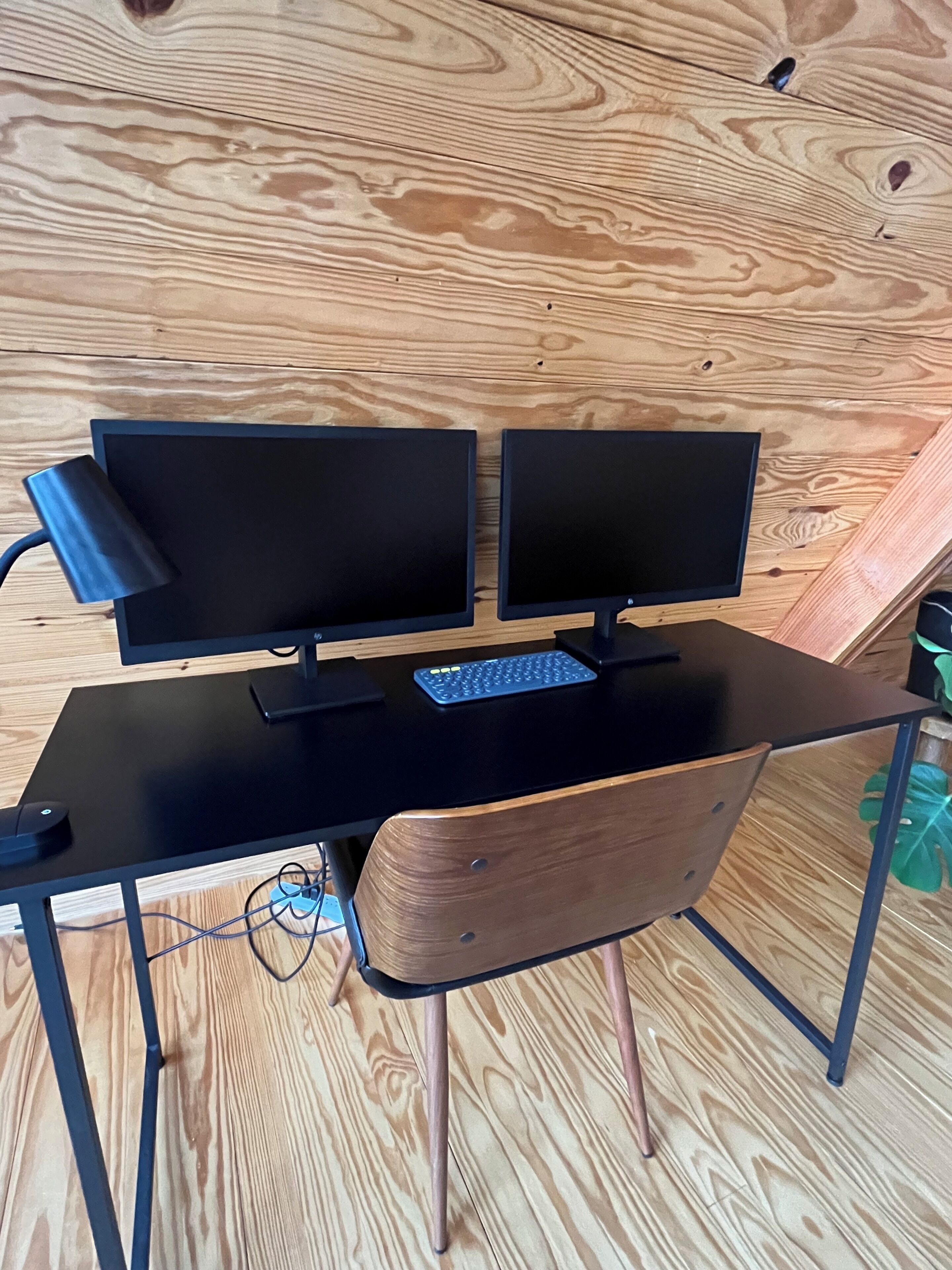 A wooden desk with two monitors, a keyboard, and a mouse.