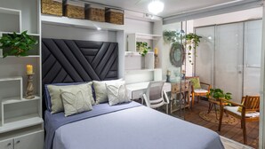 A modern bedroom with a large bed, a desk, and a seating area with chairs and a table. - Casa Ramos Salamanca (Lima)