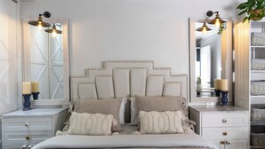 A bedroom with a large bed, two bedside tables, a dresser, and two wall-mounted lamps. - Casa Ramos Salamanca (Lima)