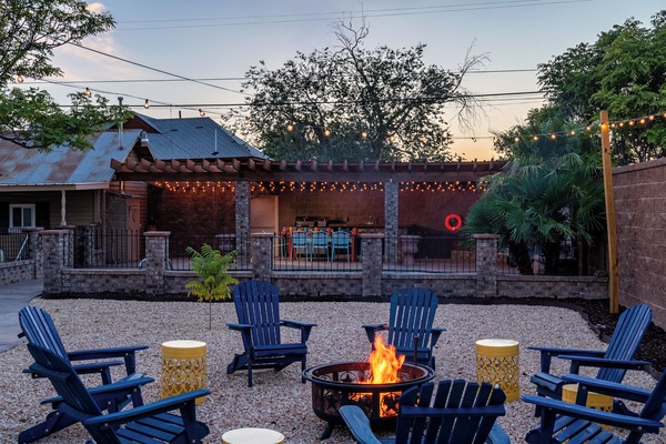 Cozy fire pit with blue Adirondack chairs, ideal for evening gatherings.