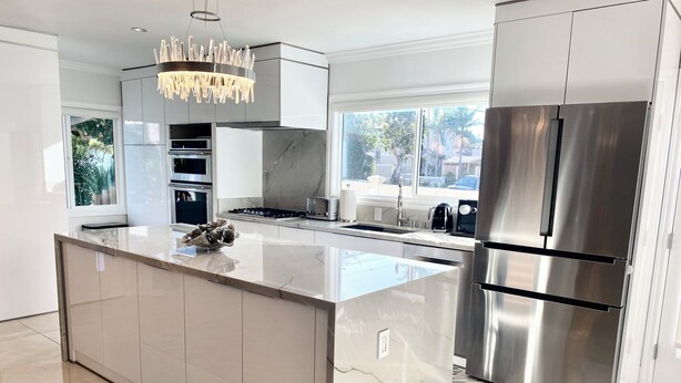 A modern kitchen with a large island, stainless steel appliances, and a view of the outdoors. - Relax with whole family at peaceful place and enjoy easy access to everything. (Redondo Beach)