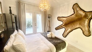 A bedroom with a bed, a large mirror, a hanging light fixture, and a mounted animal hide on the wall. - Relax with whole family at peaceful place and enjoy easy access to everything. (Redondo Beach)