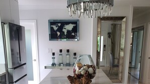A modern kitchen with a marble countertop, a decorative centerpiece, a world map on the wall, and a chandelier. - Relax with whole family at peaceful place and enjoy easy access to everything. (Redondo Beach)