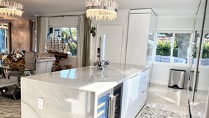 A modern kitchen with a marble island, stainless steel appliances, and a view of the outdoors. - Relax with whole family at peaceful place and enjoy easy access to everything. (Redondo Beach)