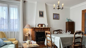 Un accogliente soggiorno con camino, un tavolo da pranzo con sedie, un divano e una lampada.