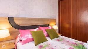 A hotel room with a wooden headboard, a floral bedspread, and two bedside lamps. - Charming Apartment & Diving La Restinga (La Restinga)