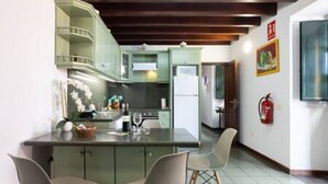 A kitchen with a central island, two chairs, and a refrigerator. - La Pestilla 3 - Cozy rustic house, El Hierro (Taibique)