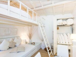 A room with a bunk bed, a ladder, a bedside table with a lamp, and a shelf with rolled towels. - PANTHEON SPLENDID FLAT WITH TERRACE (Roma)