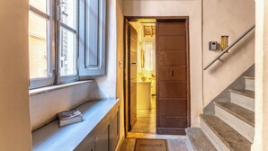 Un couloir avec un banc, une porte et un escalier.