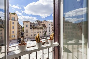 Un balcon agrémenté de cactus en pot et offrant une vue sur des bâtiments historiques.