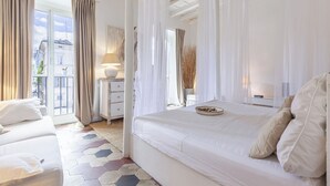 Un dormitorio con una cama grande, una mesita de noche, una lámpara y vistas al exterior.