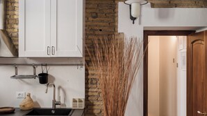 Une cuisine avec des armoires blanches, un évier noir et une table en bois.