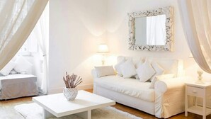 A white-themed living room with a sofa, a coffee table, and a lamp. - SPLENDID APARTMENT TRASTEVERE (Roma)