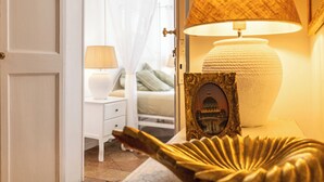 A bedroom with a bed, bedside lamps, a nightstand, and a decorative item on the nightstand. - CAMPO DEI FIORI ELITE LUXURY FOR 10 GUESTS (Roma)