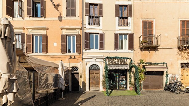 A cobblestone street with buildings featuring arched doorways and windows with shutters. - CAMPO DEI FIORI ELITE LUXURY FOR 10 GUESTS (Roma)