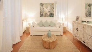 A living room with a white sofa, two side tables, a wooden coffee table, and a cabinet with decorative items. - CAMPO DEI FIORI ELITE LUXURY FOR 10 GUESTS (Roma)