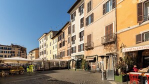 A cobblestone street with buildings, outdoor seating, and a restaurant named 'ROMOLETTO'. - CAMPO DEI FIORI ELITE LUXURY FOR 10 GUESTS (Roma)