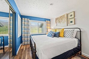 Ein Schlafzimmer mit Bett, Vorhängen und Bildern an der Wand.