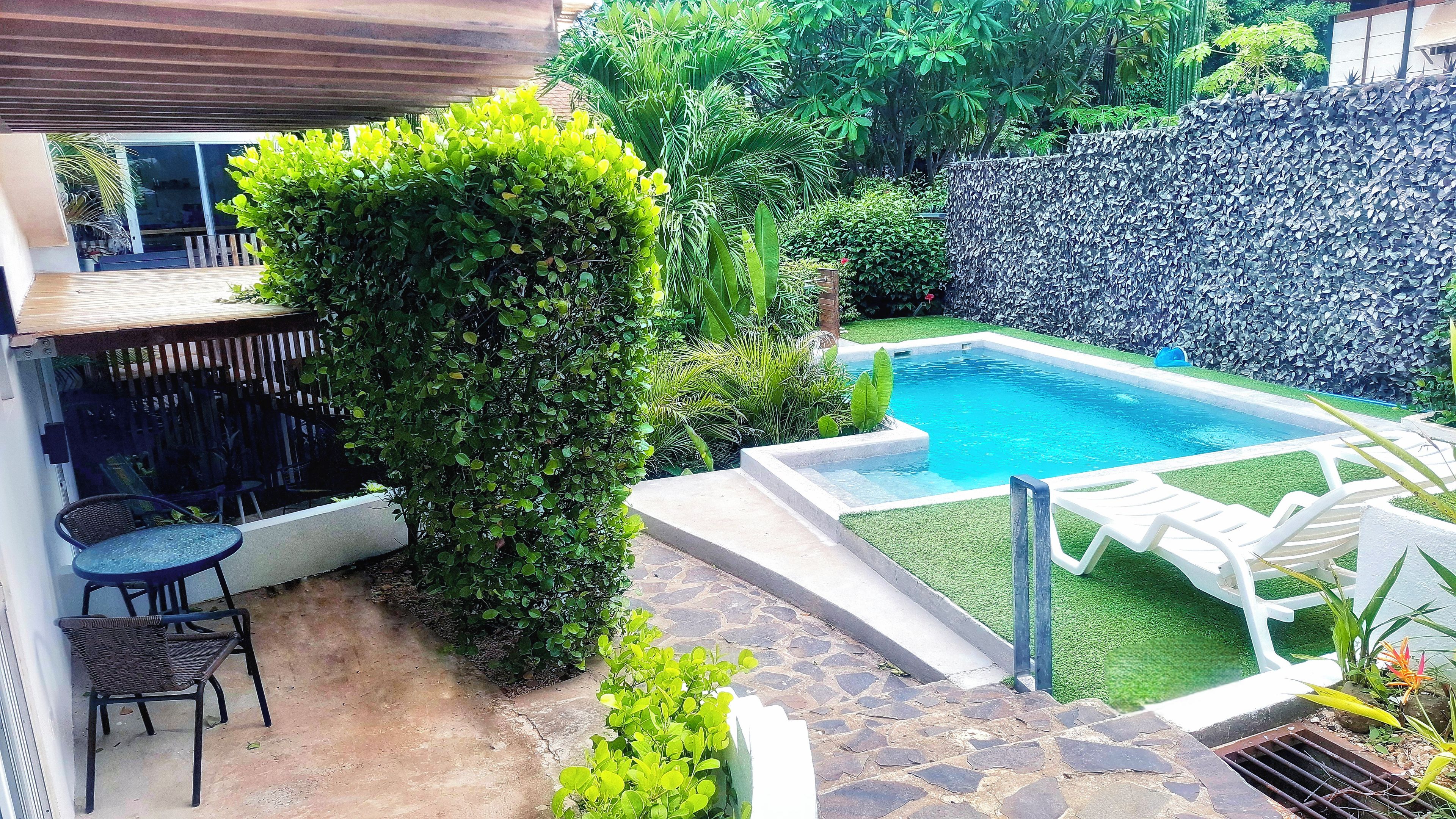 Ein Garten mit Schwimmbad, Terrasse und Gartenweg.