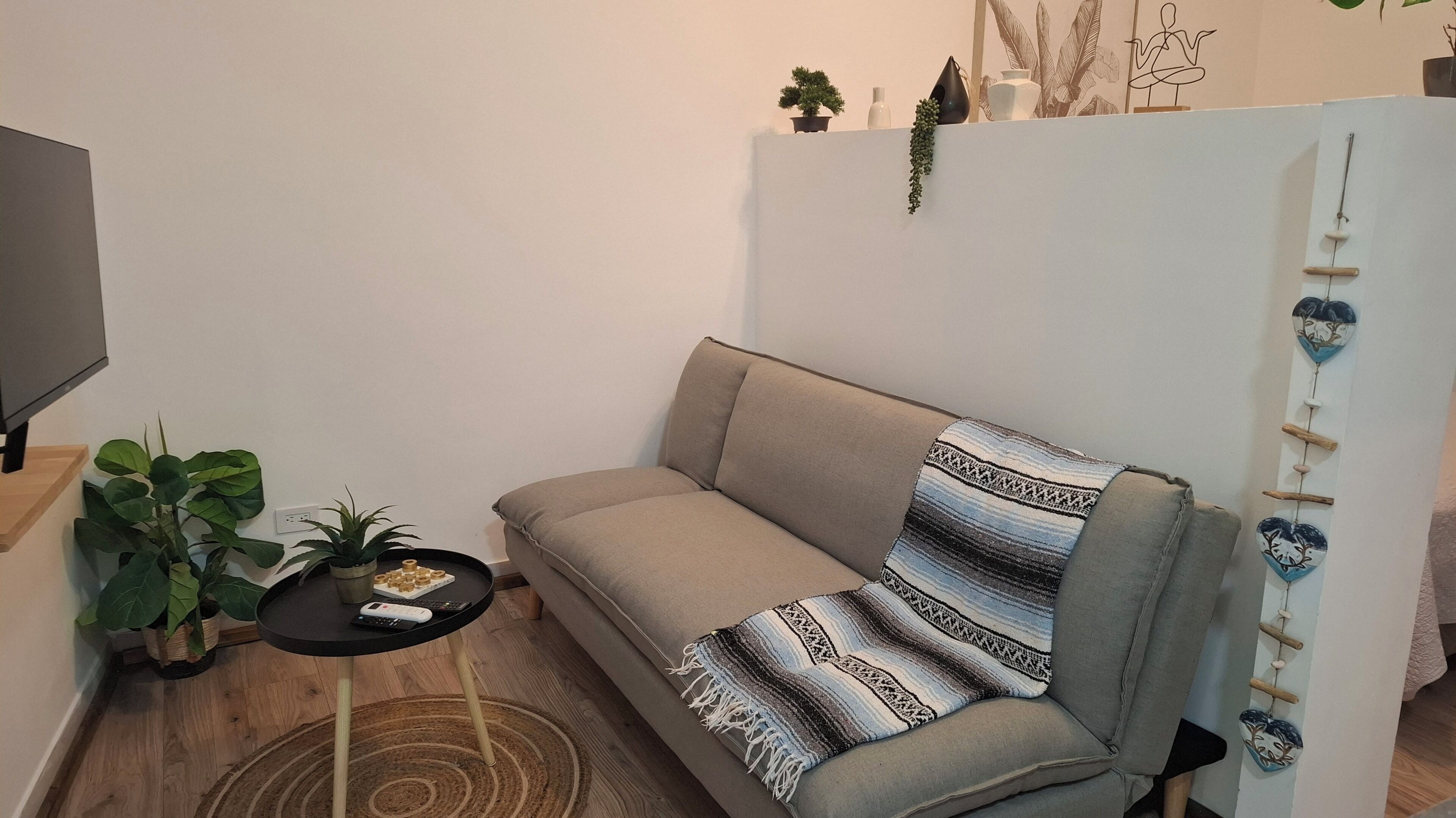 Una sala de estar moderna con un sofá, una mesita y un televisor.