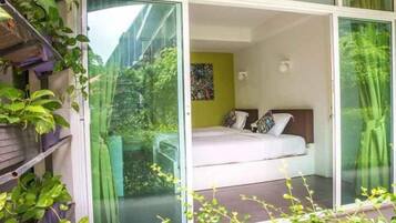 Une chambre à coucher avec un lit, une fenêtre et une plante.
