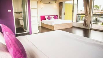 A bedroom with a bed, a bathroom, and a balcony.