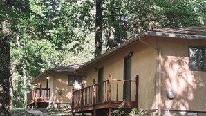 Een rij vakantiehuisjes met houten terrassen en een overdekte gang.