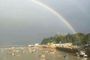A coastal scene with boats, a rainbow, and buildings along the shore. - Fuding Yushan Island Luzhu Village Jiayuan Homestay (Fuding)