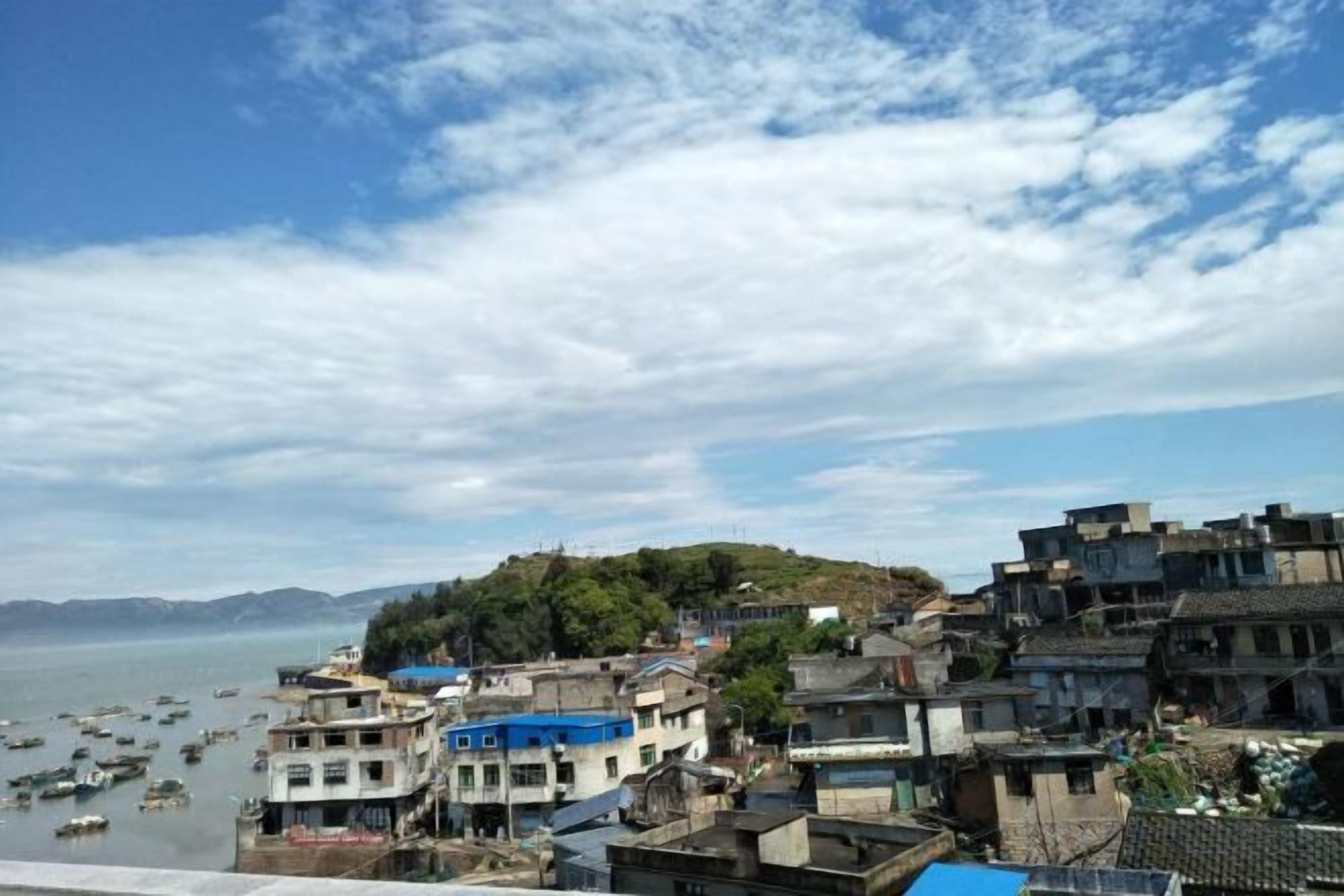 A coastal town with buildings, boats, and a clear sky.