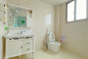 A bathroom with a white vanity, a toilet, and a window. - Fuding Yushan Island Luzhu Village Jiayuan Homestay (Fuding)