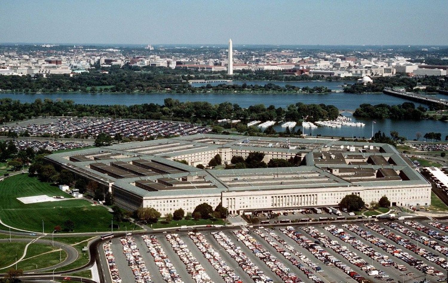 A large, rectangular building with a central courtyard surrounded by parking.