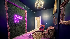 A room with a neon sign reading "Galleria For You," a chandelier, and ornate furniture against dark walls. - Gallant Fox - NuLu/Downtown (Louisville)