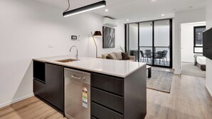 Una cocina moderna con lavavajillas, una isla grande y un comedor con mesa y sillas.