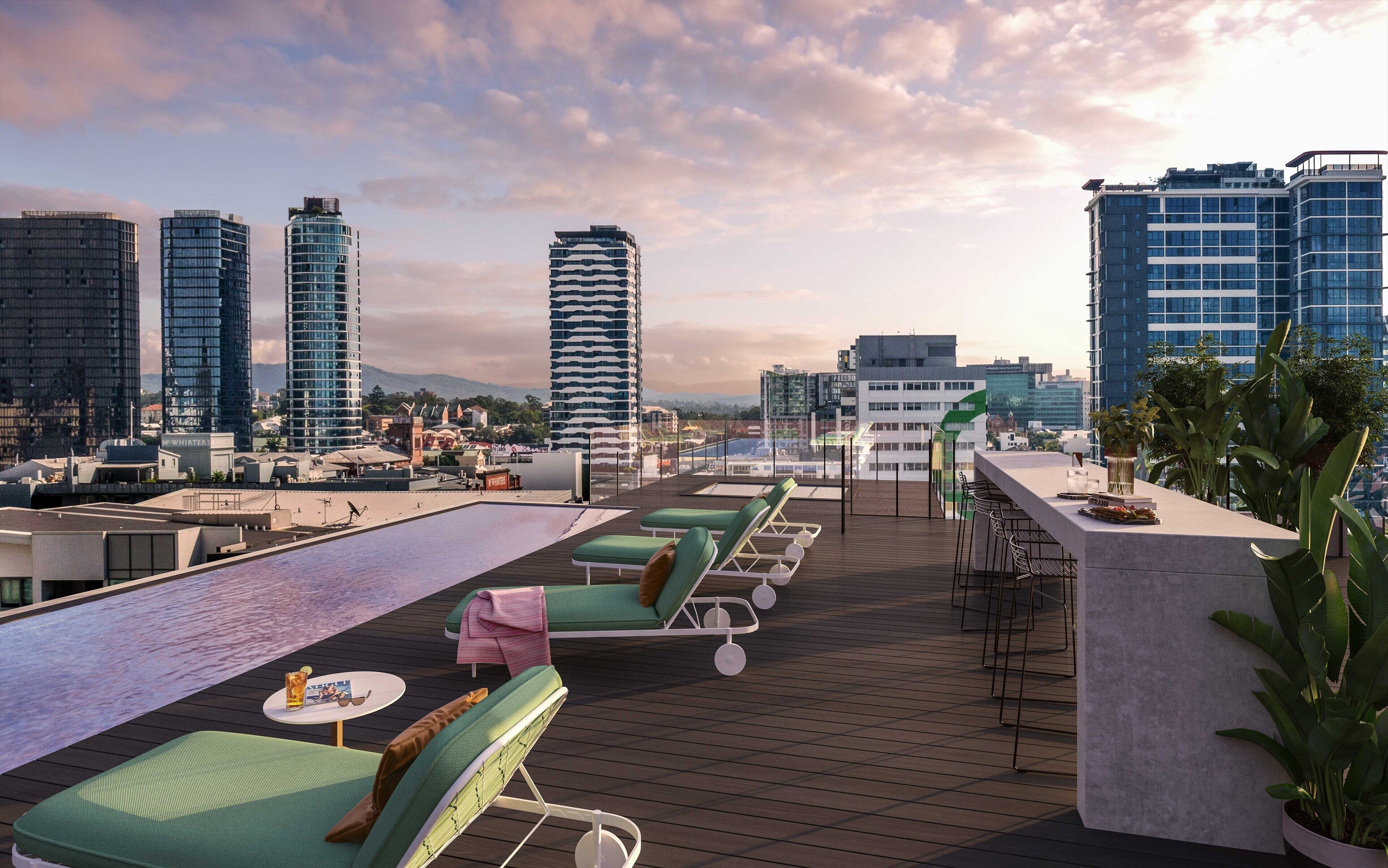 A rooftop terrace with lounge chairs, a pool, and a city view.