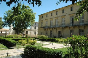 Un patio con un edificio que tiene varias ventanas y una estatua.