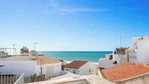Vista costera con edificios, cielo despejado y el mar.