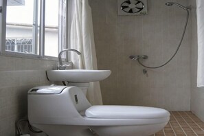 Un baño con inodoro, lavamanos y ducha.