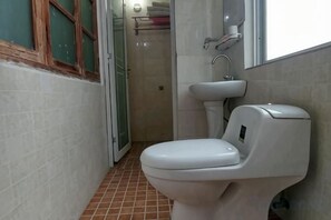 A bathroom with a toilet, sink, and a shower area. - Yangshuo Culture House (Yangshuo)