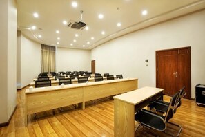 A conference room with a long table, chairs, a projector, and a wooden floor. - Lanmeishan Business Hotel (Pu'er Simao Airport) (Pu'er)