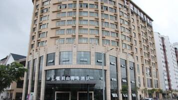Un immeuble à plusieurs étages doté d’une façade incurvée, de grandes fenêtres et d’une entrée imposante.