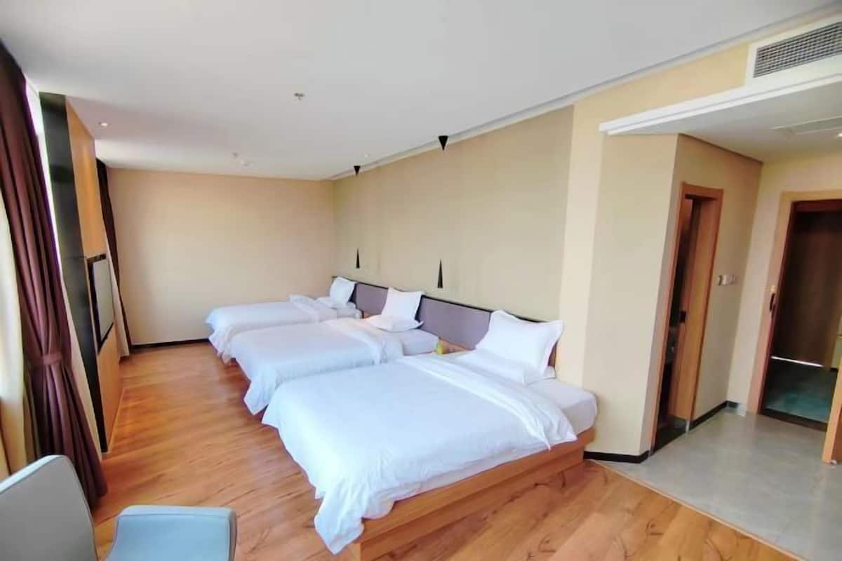 Een hotelkamer met een groot bed, een bureau en een kledingkast.