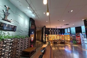 Eine Hotelhalle mit Rezeption, einer Sitzgelegenheit und einer Übersicht über die Annehmlichkeiten.