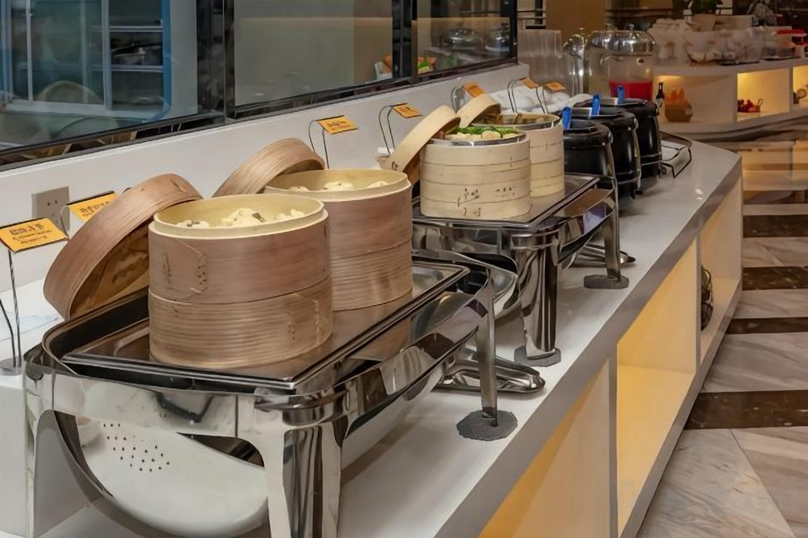 Un buffet avec différents plats présentés dans des récipients et un espace dédié aux boissons.