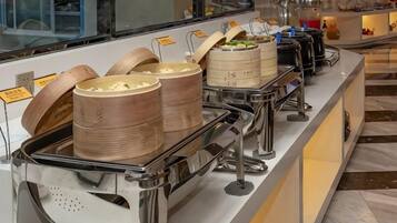 Un buffet avec différents plats présentés dans des récipients et un espace dédié aux boissons.