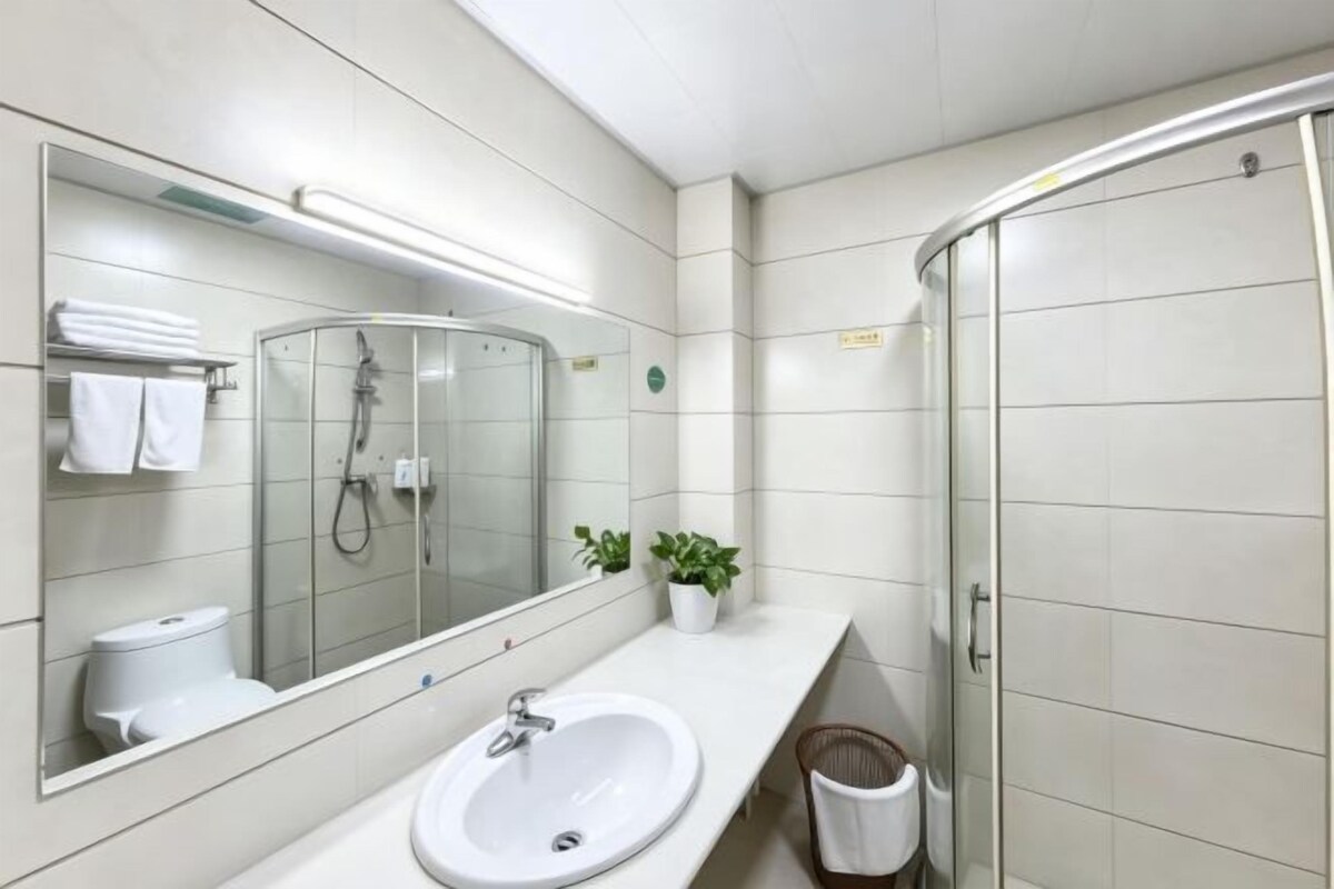 A modern bathroom with a glass shower enclosure, a sink, and a mirror.