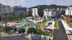 A residential area with multi-story buildings, a playground, and a road. - Jinqiu Courtyard Hotel (Shaowu)